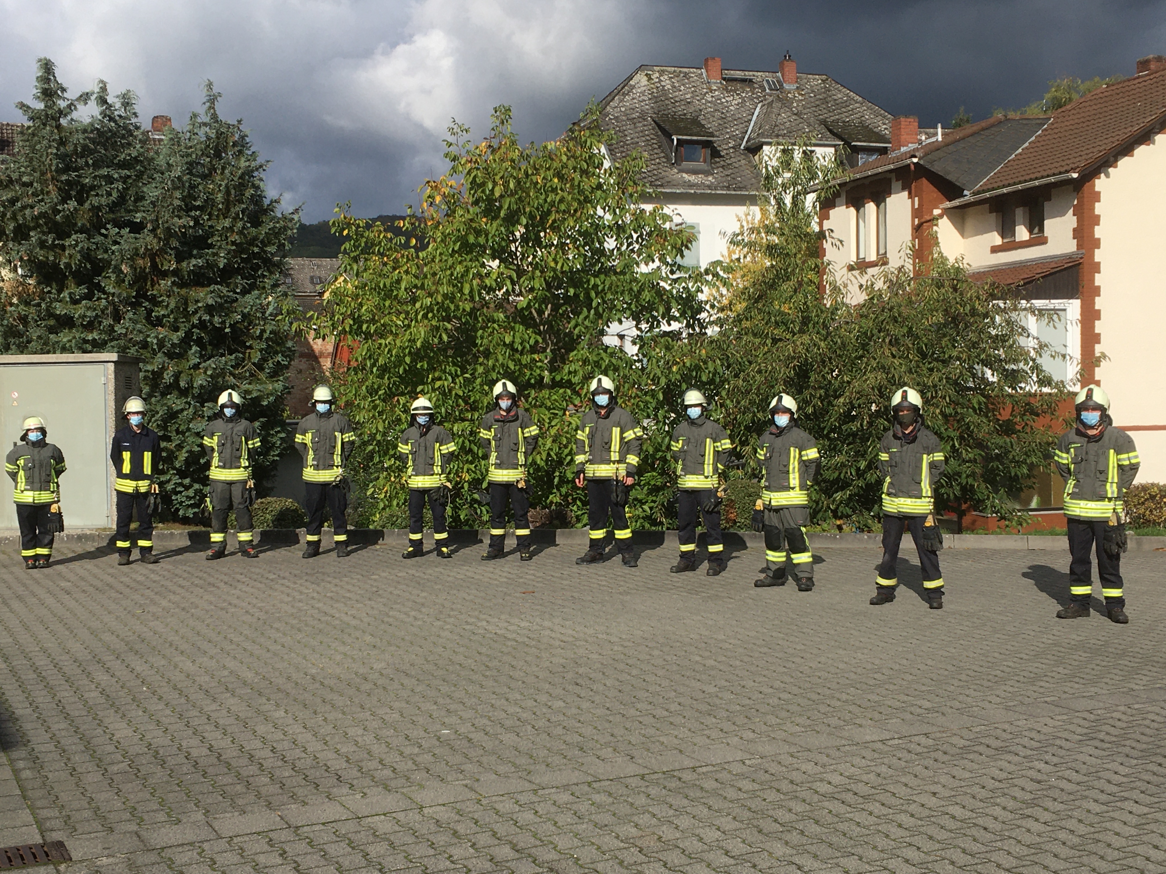 Elf Feuerwehrangehörige im Gruppenbild mit Abstand