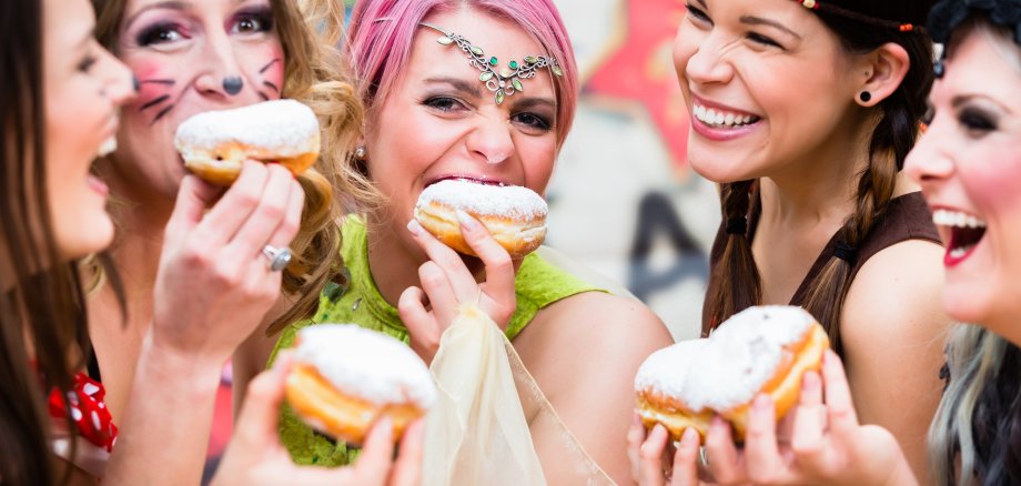 Girls at German Fasching Carnival eating doughnut-like traditional pastry